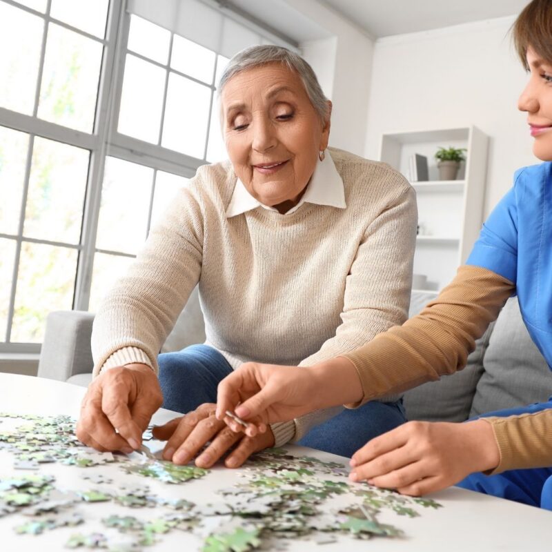 Elderly person sitting with a caregiver at home, representing Alzheimer's patients and families exploring medical marijuana evaluation options in Ohio through KAV THC